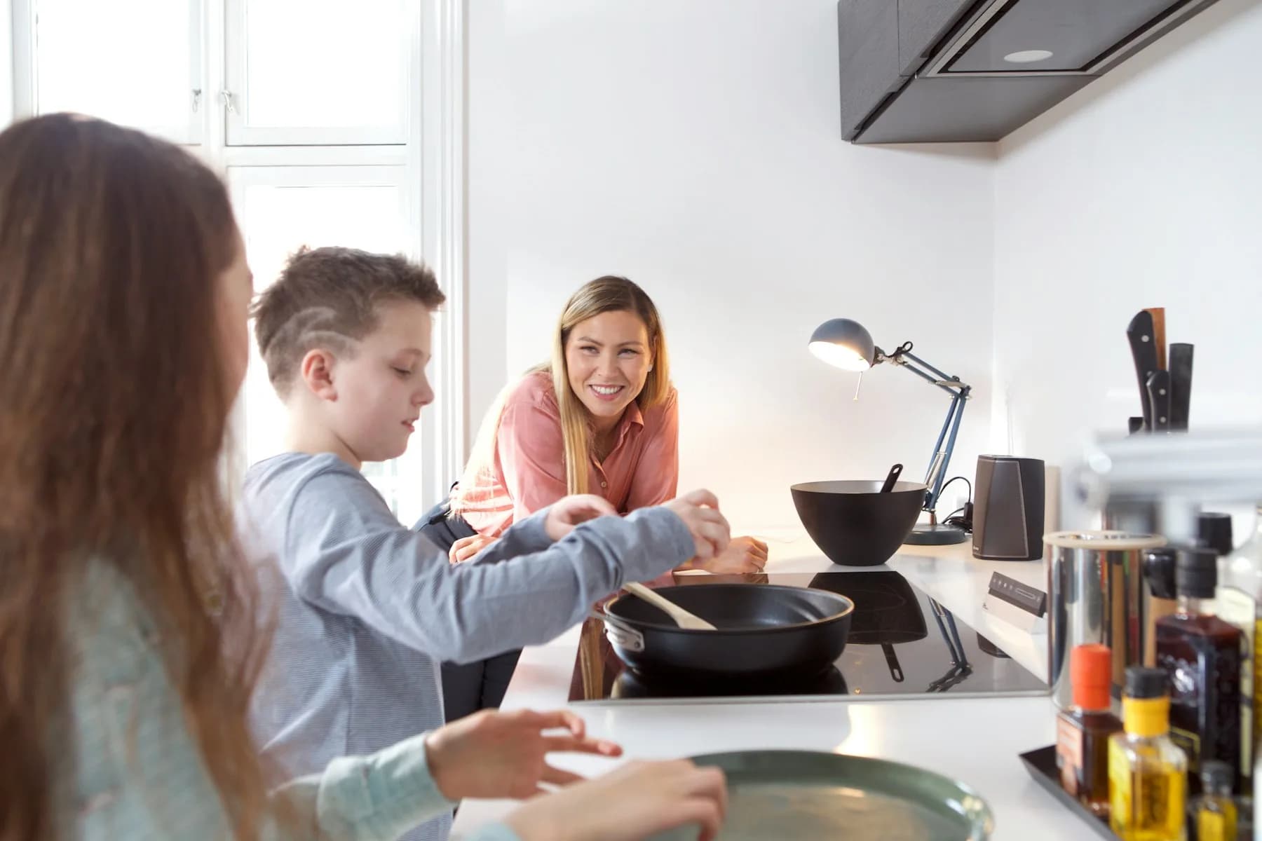 A family cooking together at the kitchen counter